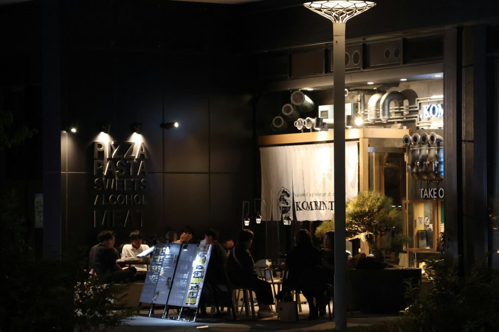 People dine at an outdoor cafe at night.