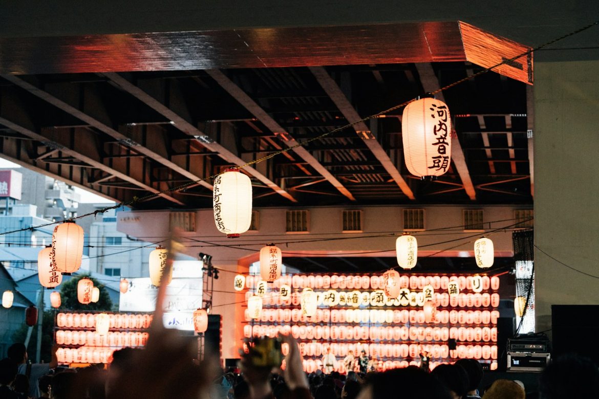 Paper lanterns hang under a bridge during a festival.